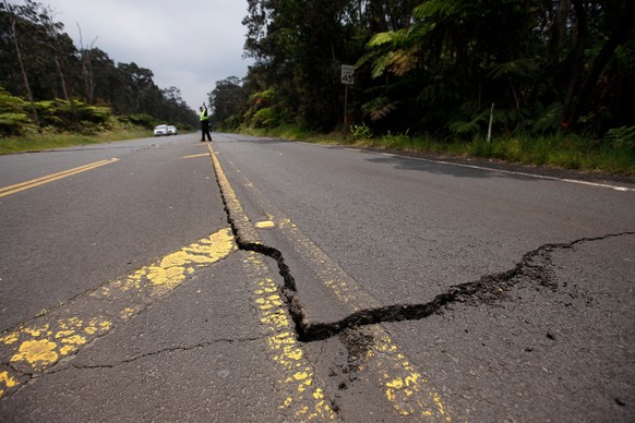 epa06743252 Police inspect cracks in Highway 11 after a 3.5 magnitude earthquake hit the area near the entrance to Hawaii Volcanoes National Park, Hawaii, USA, 16 May 2018. A 3.5 magnitude earthquake  ...
