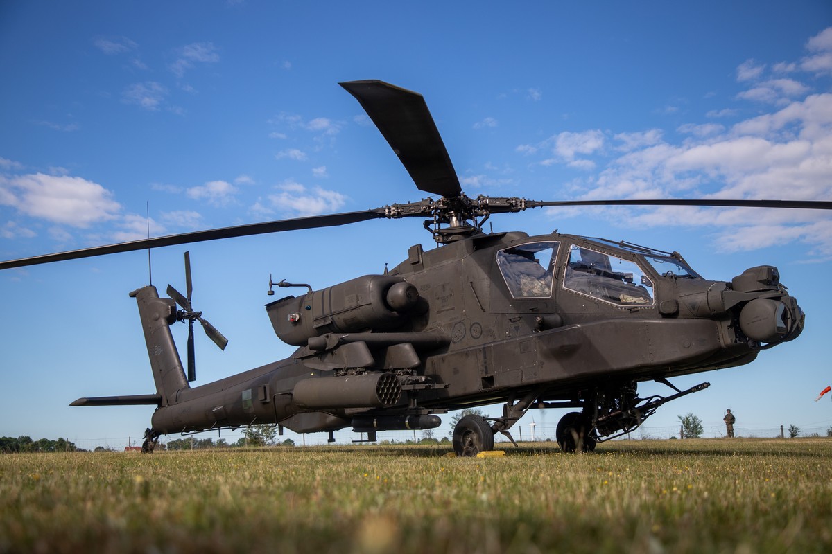 epa13001472 A Boeing AH-64 Apache helicopter is parked on a field during the 'Polish Apache Initiative 4 / European HIMARS Initiative 8' joint military exercise at a training ground in Kijew ...