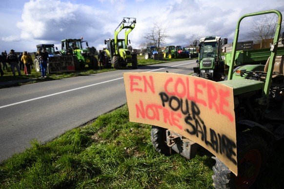 Traktoren mit Slogans stehen am Straßenrand während der Aktion &quot;Protestfeuer für die Landwirtschaft&quot;, die von der Facebook-Gruppe &quot;Revolte agricole Suisse&quot; anlässlich der Revolte d ...