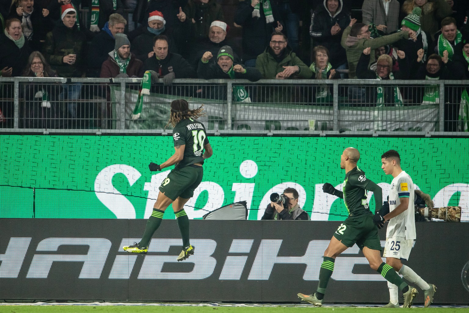 18.12.2019, Niedersachsen, Wolfsburg: Fußball: Bundesliga, VfL Wolfsburg - FC Schalke 04, 16. Spieltag in der Volkswagen-Arena. Wolfsburgs Kevin Mbabu (l) jubelt nach seinem Tor zum 1:1 Foto: Swen Pfö ...