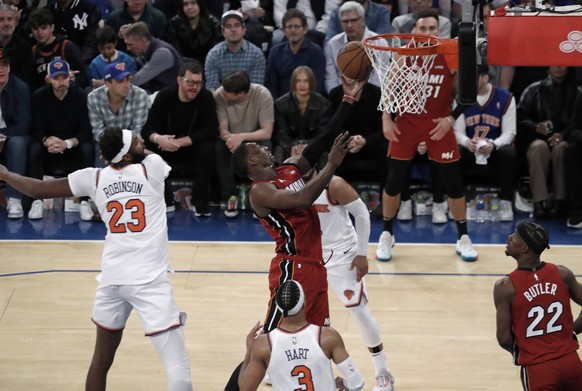 epa10601101 Miami Heat center Bam Adebayo (C) shoots over New York Knick defenders during the second half of game one of the Eastern Conference Semifinals playoff series between the Miami Heat and the ...