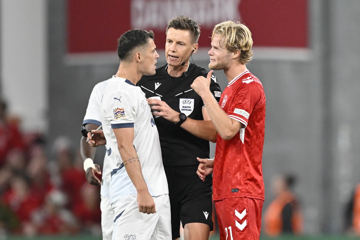 Switzerland's Granit Xhaka, referee Daniel Siebert and Denmark's Morten Hjulmand, from left, argue during the UEFA Nations League Group D leg 1 soccer match between Denmark and Switzerland,  ...