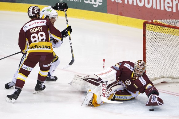 Geneve-Servette&#039;s goaltender Robert Mayer, right, saves a pick past Geneve-Servette&#039;s center Kevin Romy, left, and Biel&#039;s center Gaetan Haas, center, during the game of National League  ...