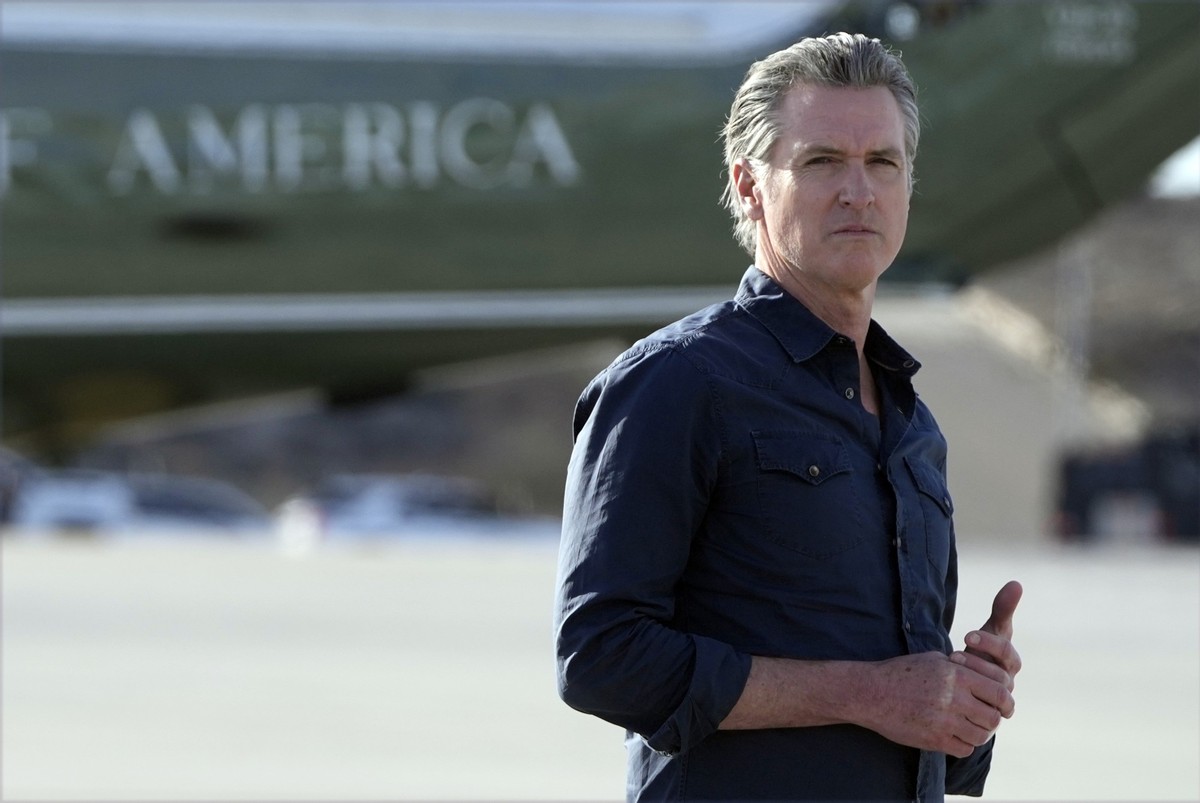 California Gov. Gavin Newsom waits for President Donald Trump and first lady Melania Trump to step off Air Force One upon their arrival at Los Angeles International Airport in Los Angeles, Friday, Jan ...