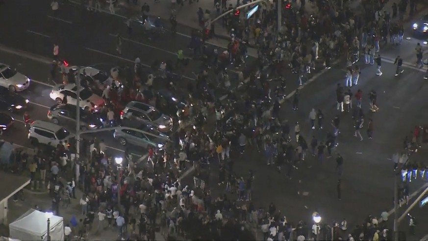 This Saturday, May 22, 2021 aerial screenshot provided by FOX 11 KTTV shows people gathered at the Huntington Beach pier in Huntington Beach, Calif. Police in Huntington Beach estimate that at least 1 ...