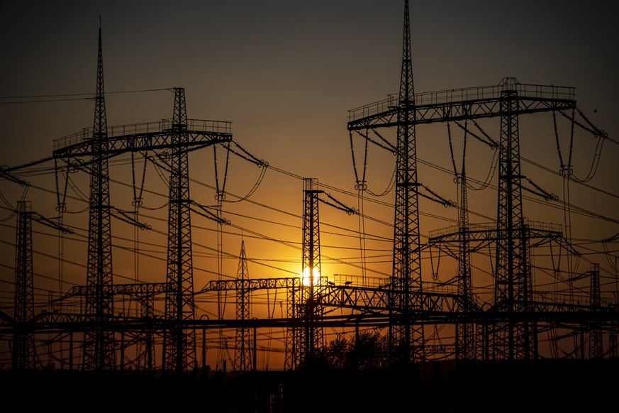 epa10080635 Electricity pylons stand in a substation at sunset in Nosovice, Czech Republic, 19 July 2022. Some Czech energy suppliers have been raising prices again for some customers since August 202 ...