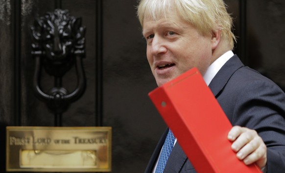 FILE - In this Tuesday, Oct. 10, 2017 file photo Britain&#039;s then Foreign Secretary Boris Johnson waves to the media as he arrives for a cabinet meeting at 10 Downing Street in London. A British ju ...