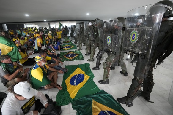 Protesters, supporters of Brazil&#039;s former President Jair Bolsonaro, are confronted by police in riot gear after they stormed the Planalto Palace in Brasilia, Brazil, Sunday, Jan. 8, 2023. Planalt ...