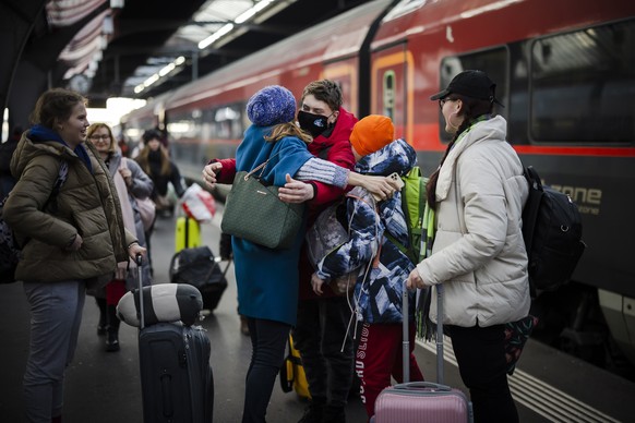 epa09813020 A youth from Ukraine reacts as he receives a hug after his arrival with his family at Zurich's central station, following Russia's invasion of Ukraine, in Zurich, Switzerland, 09 ...