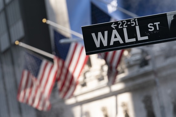 FILE - A sign for Wall Street hangs in front of the New York Stock Exchange, July 8, 2021. Stocks are opening with slight gains on Wall Street Thursday, Dec. 30, keeping the S&amp;P 500 and the Dow Jo ...