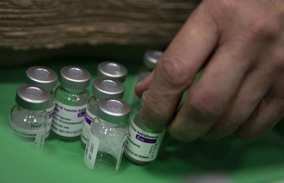 A pharmacist picks up an empty vial of the AstraZeneca COVID-19 vaccine at the Vaccine Village in Antwerp, Belgium on Tuesday, March 16, 2021. Belgium on Tuesday reaffirmed its support to AstraZeneca  ...