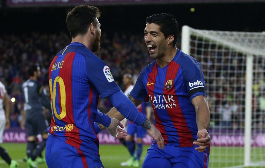 FC Barcelona&#039;s Luis Suarez, right, celebrates with his teammate Lionel Messi after scoring during the Spanish La Liga soccer match between FC Barcelona and Sevilla at the Camp Nou stadium in Barc ...