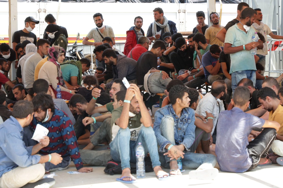 epa10089488 Migrants arrive at the 'molo di Norimberga' (Nuremberg pier) in Messina, Sicily Island, southern Italy, 24 July 2022. Over 600 migrants on board a drifting fishing boat have been ...