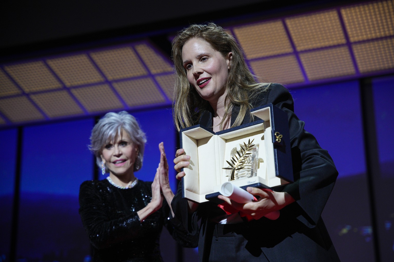 Justine Triet, right, accepts the Palme d&#039;Or for &#039;Anatomy of a Fall,&#039; which was presented by Jane Fonda, left, during the awards ceremony of the 76th international film festival, Cannes ...