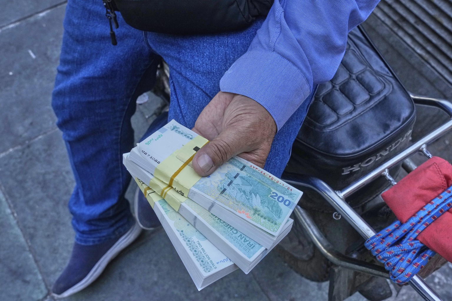 A street money exchanger holds Iranian banknotes at Ferdowsi square, Tehran&#039;s go-to venue for foreign currency exchange, in downtown Tehran, Iran, Thursday, Aug. 28, 2025. (AP Photo/Vahid Salemi) ...