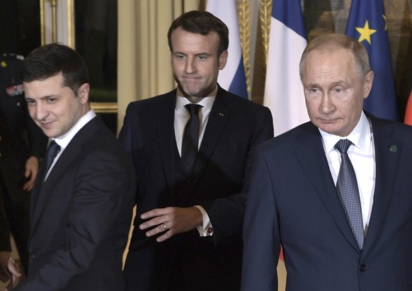 FILE - French President Emmanuel Macron, centre, Russian President Vladimir Putin, right, and Ukrainian President Volodymyr Zelenskiy, left, arrive for a working session at the Elysee Palace, in Paris ...