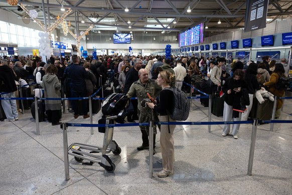 Passengers gather at a departures hall of Athens' Eleftherios Venizelos international airport in Athens, Greece, Sunday, Jan. 4, 2026, as many flights were disrupted across Greece. (AP Photo/Yorg ...