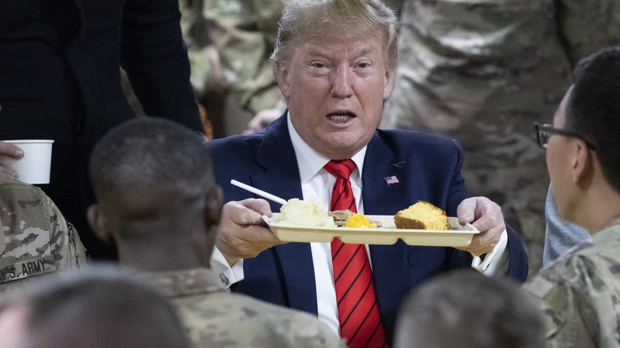 President Donald Trump holds up a tray of Thanksgiving dinner during a surprise Thanksgiving Day visit to the troops, Thursday, Nov. 28, 2019, at Bagram Air Field, Afghanistan. (AP Photo/Alex Brandon) ...