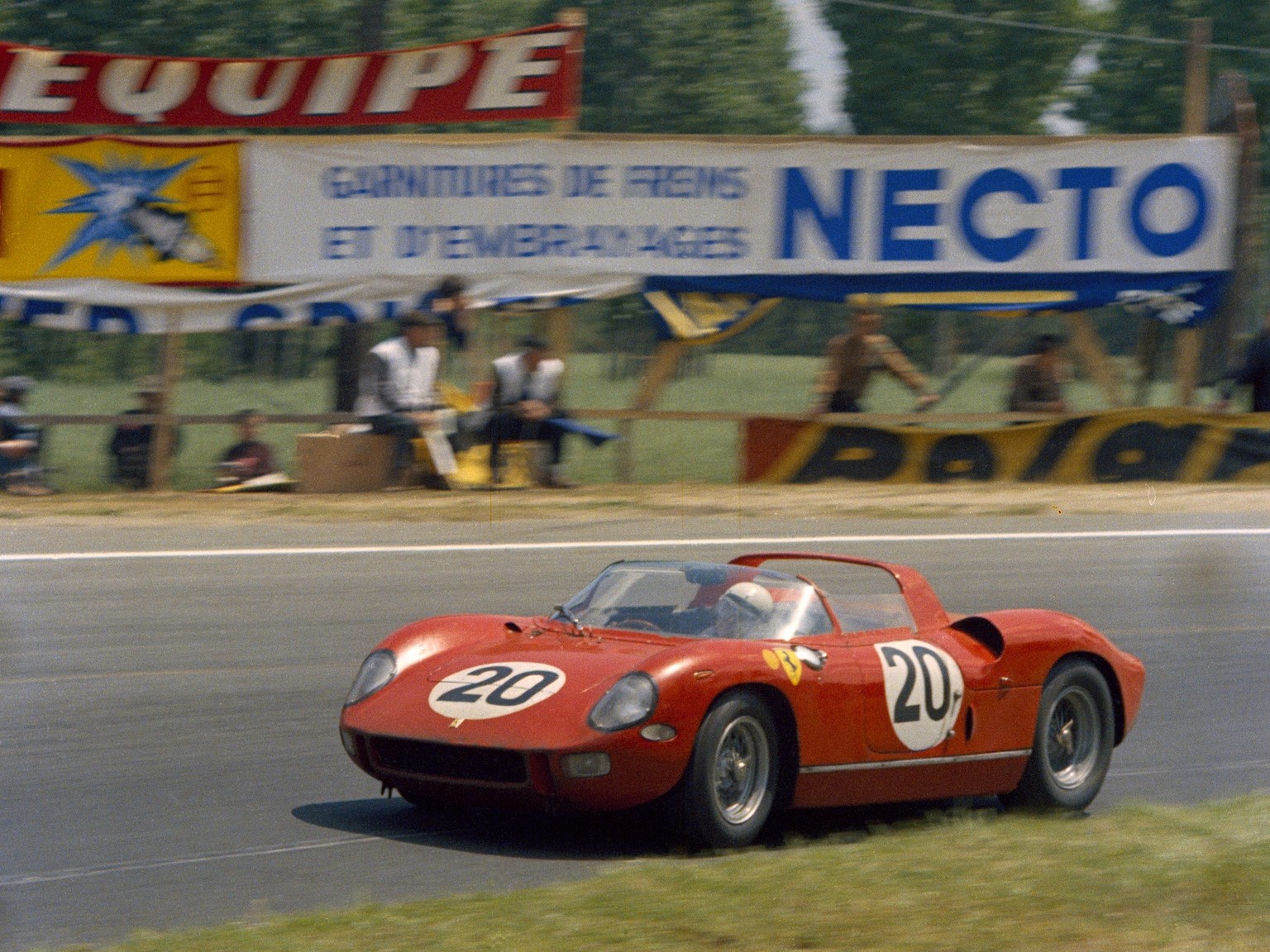 The Le Mans 24 Hours, Le Mans, June 20-21, 1964. This is the winning Ferrari 275P which was driven by Jean Guichet and Nino Vaccarella, here running through the Indianapolis corner on the back of the  ...