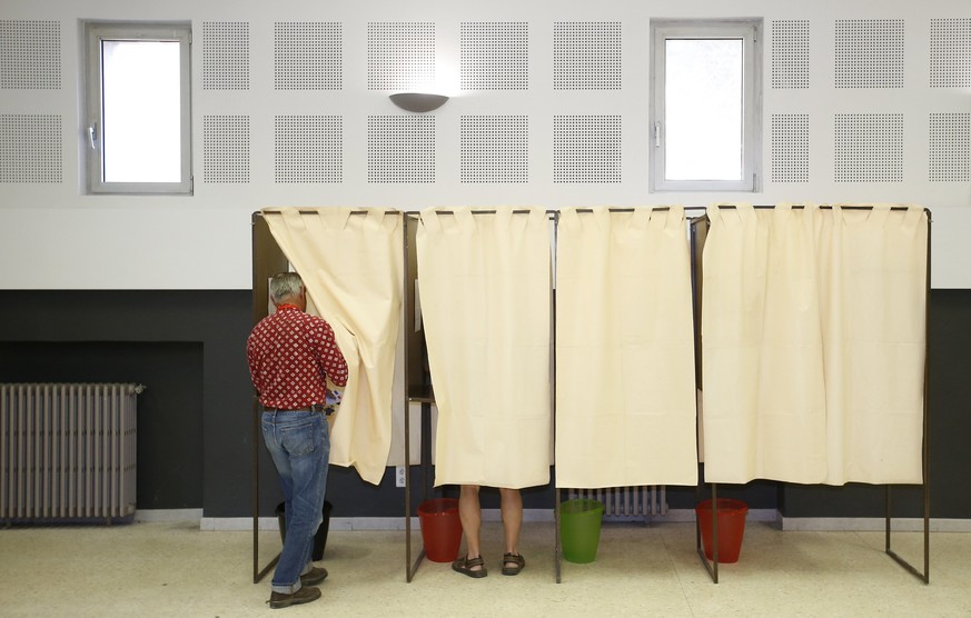 epa06022088 A man prepares to cast his ballot in a voting booth during the first round of the French legislative elections in Gallician, southern France, 11 June 2017. France holds the first round of  ...