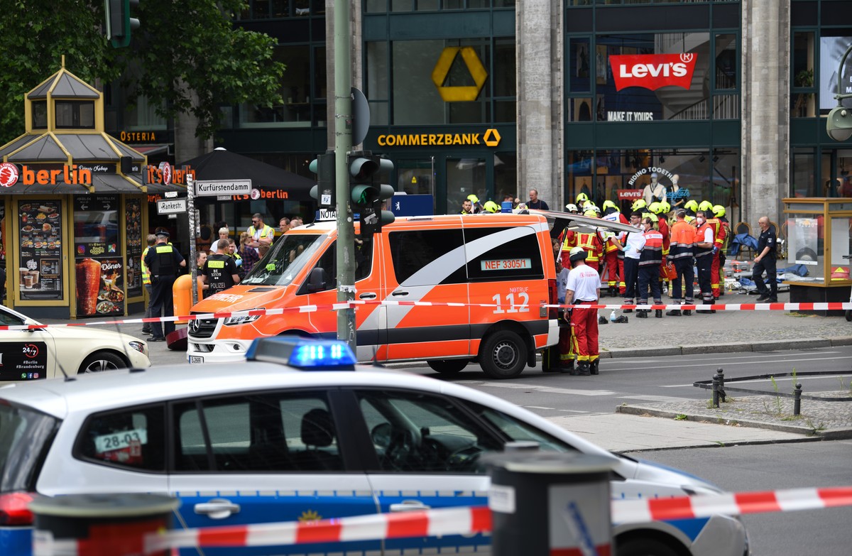 08.06.2022, Berlin: Polizei und Rettungsdienste sichern das Areal nach einem Zwischenfall. Ein Auto ist in der N