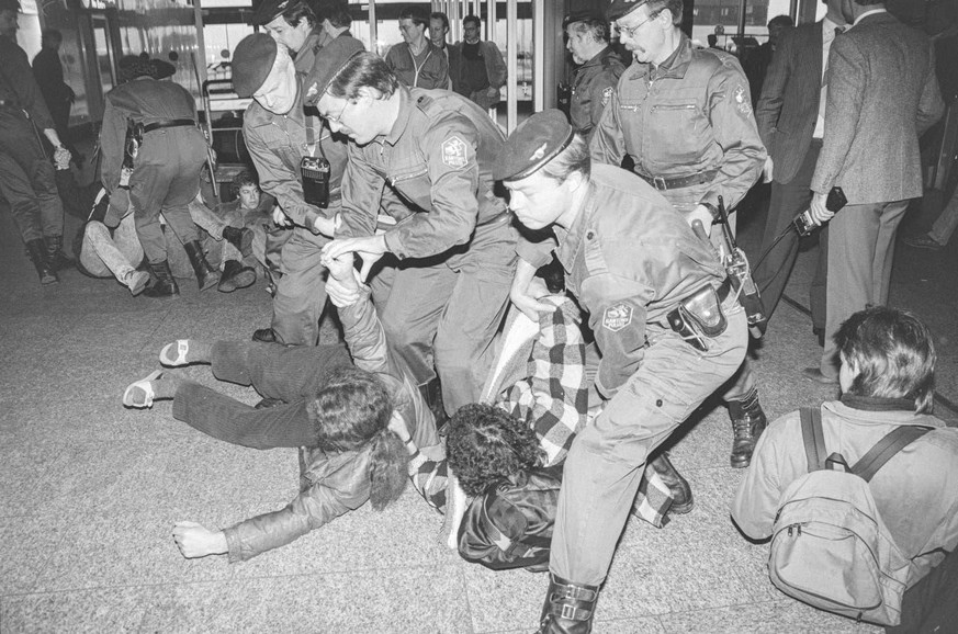 Polizisten schleppen Teilnehmende des Sitzstreiks am Flughafen Zürichs weg. (Archivbild: 12. Januar 1988)