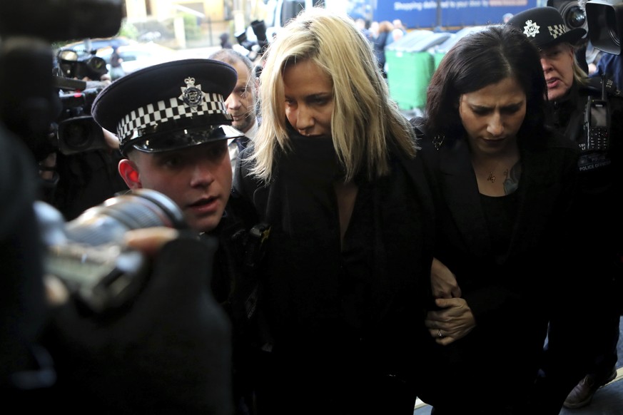 FILE - In this file photo dated Monday, Dec. 23, 2019, Love Island TV presenter Caroline Flack, centre, is escorted by police as she arrives at court in London, after being charged with assault of for ...