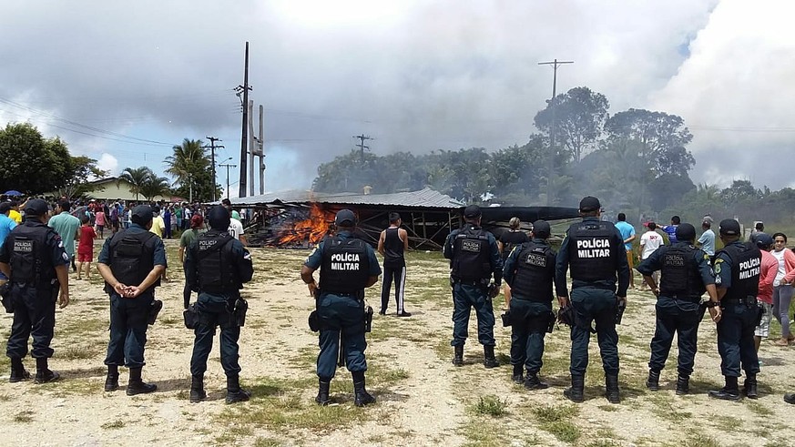 epa06957148 Police try to maintain control as Brazilian people demonstrate against the presence of Venezuelan immigrants in Pacaraima, Brazil, 18 August 2018. A group of Brazilian people demonstrated  ...