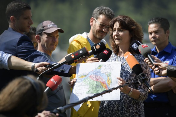 Anna Giacometti, mayor of the community Bregaglia, shows a map of Bondo, with Roman Ruegg, spokesman police Graubuenden in the background, in Bondo, Graubuenden in South Switzerland, on Friday, August ...