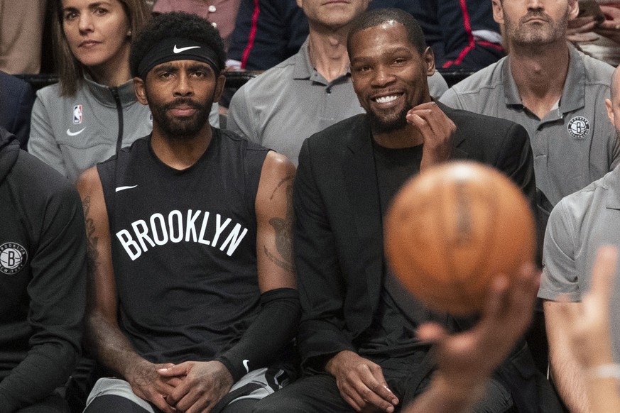 FILE - In this Nov. 1, 2019, file photo, Brooklyn Nets&#039; Kyrie Irving, left, and Kevin Durant watch the game action from the bench during the second half of an NBA basketball game against the Hous ...
