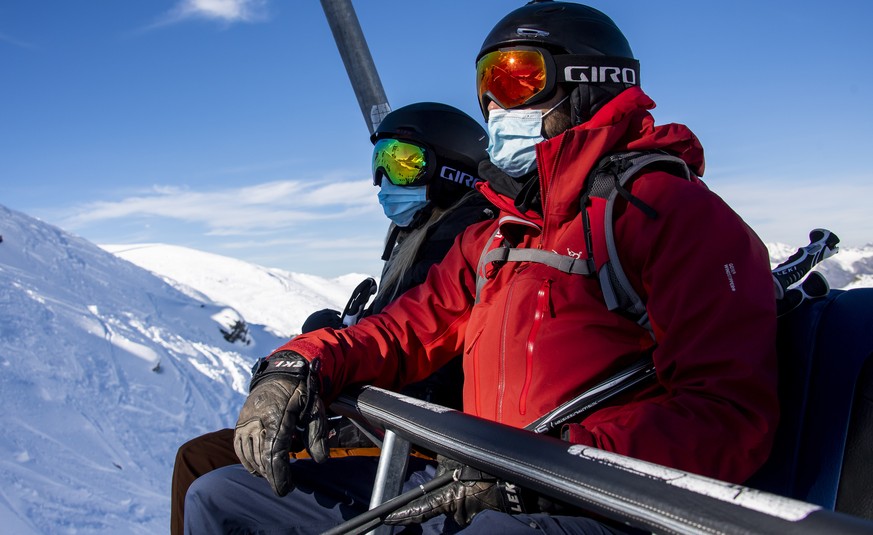 Skiers wearing face masks ride a chairlift on the opening day of the Verbier ski area in the Swiss Alps during the coronavirus disease (COVID-19) outbreak, in Verbier, Switzerland, Friday, Oct. 30, 20 ...