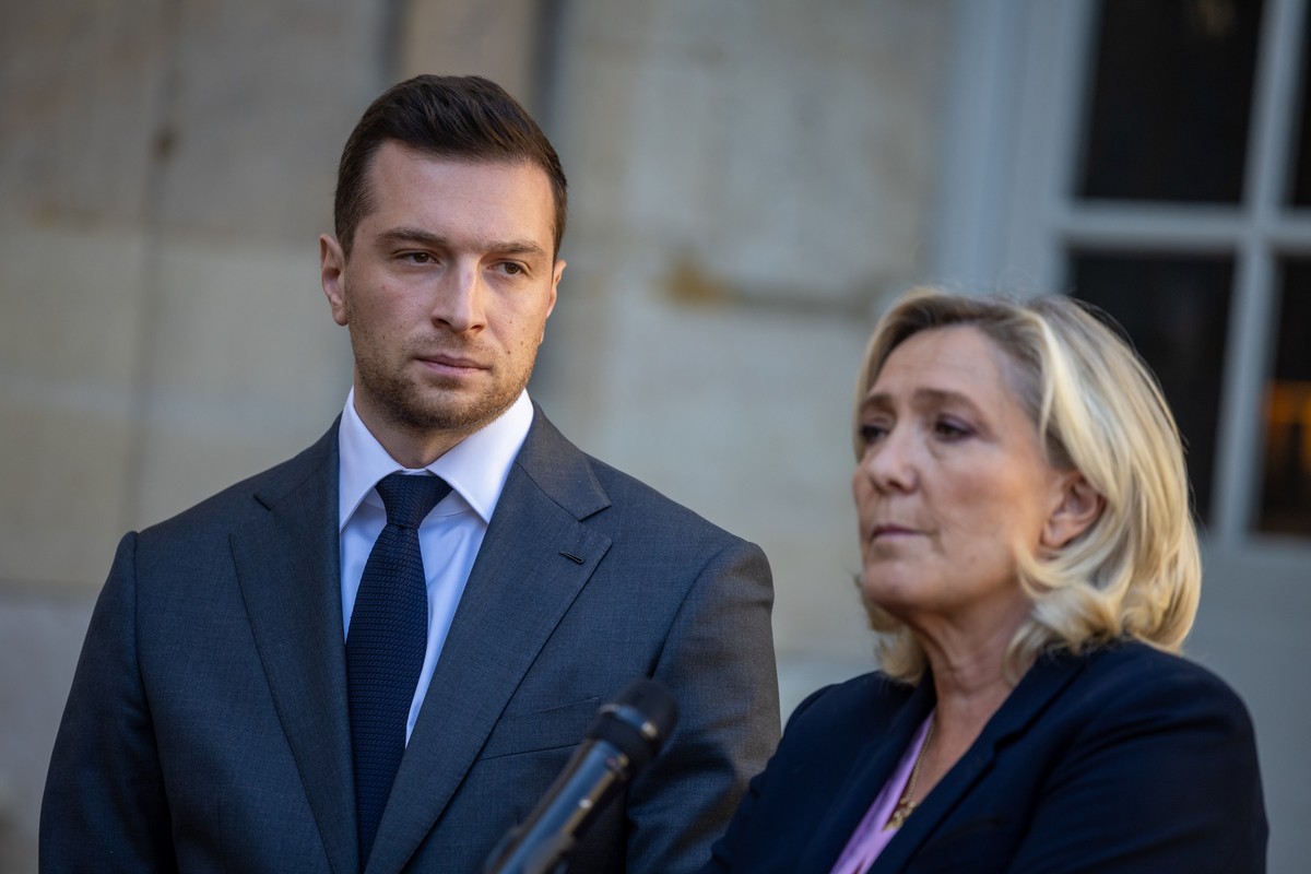 epa12064513 President of the far-right Rassemblement National (RN) Jordan Bardella (L) looks on as RN president of the parliamentary group Marine Le Pen (R) speaks to the media after a meeting with th ...