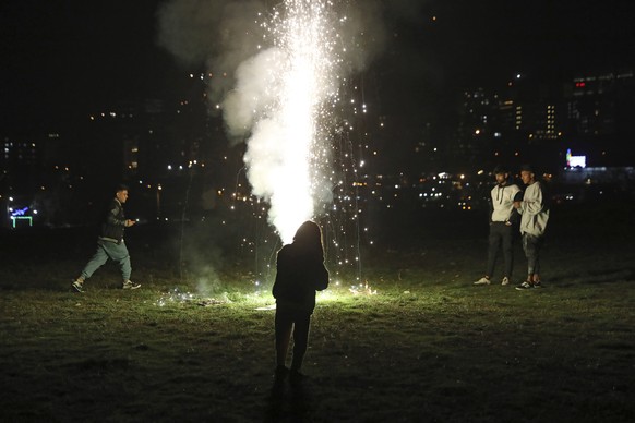 People light a firework while celebrating Chaharshanbe Souri, or Wednesday Feast, an ancient Festival of Fire, on the eve of the last Wednesday of the solar Persian year, in Tehran, Iran, Tuesday, Mar ...