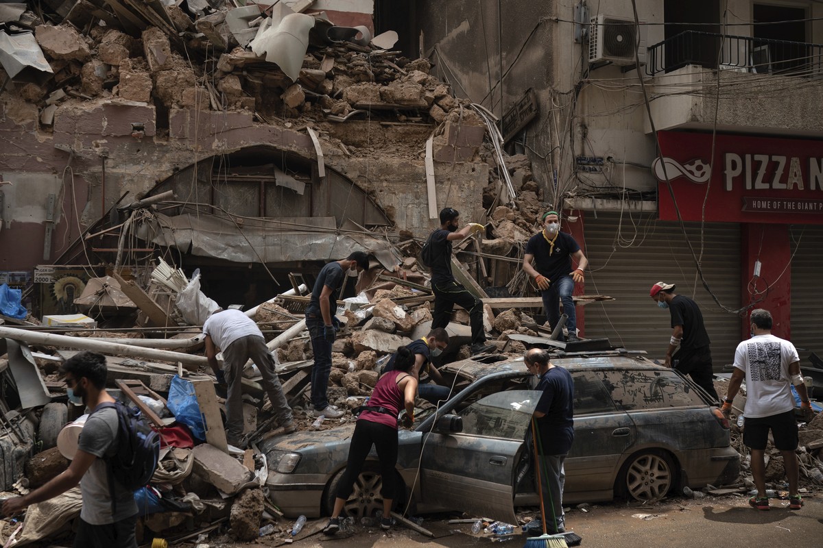 People remove debris from a house damaged by Tuesday's explosion in the seaport of Beirut, Lebanon, Friday, Aug. 7, 2020. Rescue teams were still searching the rubble of Beirut's port for bo ...