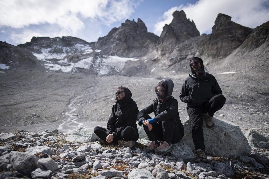 epa07861170 Activists sit in front of the Pizol glacier and mountain during a commemoration for the dying glacier of Pizol mountain, in Wangs, Switzerland, 22 September 2019. Various organizations gat ...