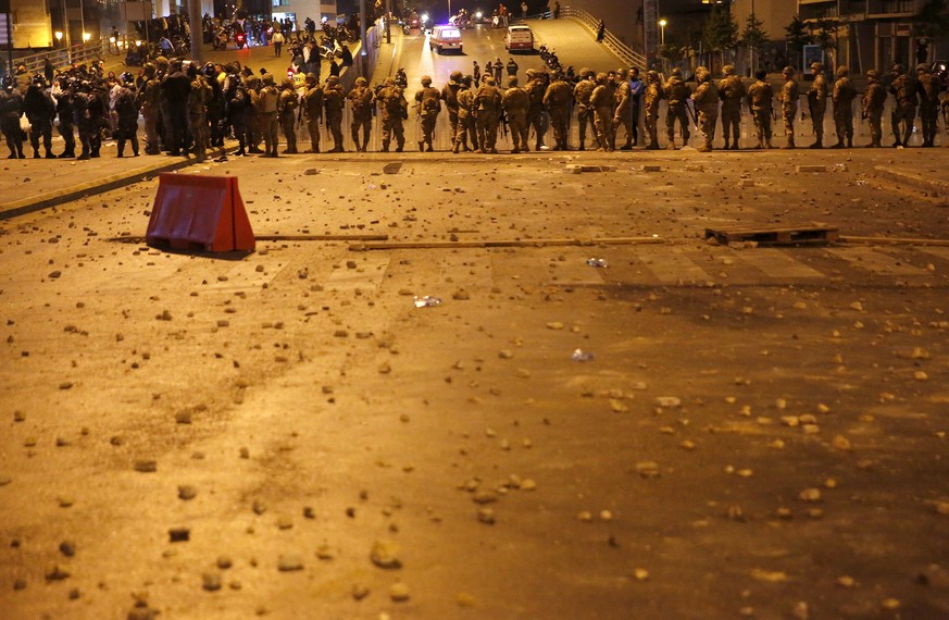 Lebanese army soldiers stand guard as a clash erupted between supporters of the Shiite Hezbollah and Amal groups and the anti-government protesters, in Beirut, Lebanon, early Monday, Nov. 25, 2019. Se ...