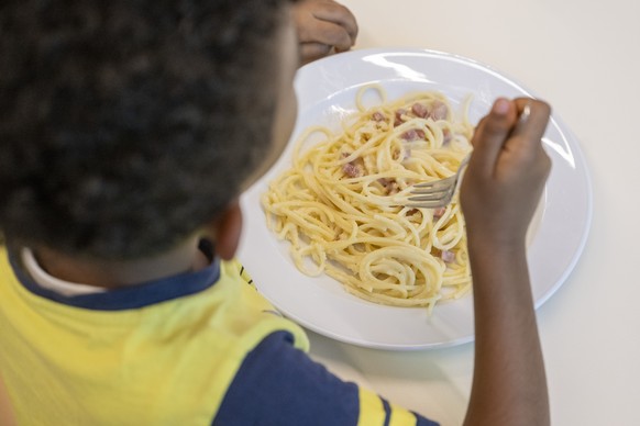 Ein Schulkind der Tagesschule im Schulhaus der Volksschule Littau Dorf in Luzern geniessen Spaghetti Carbonara waehrend ihrer Mittagspause am Montag, 15. September 2025 in Littau. Die Volksschule der  ...