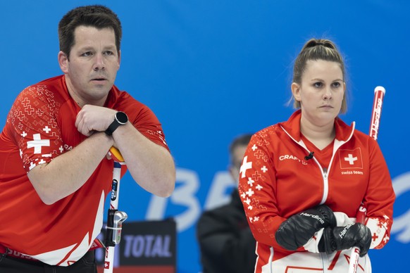 Martin Rios, left, and Jenny Perret of Switzerland team during curling mixed doubles preliminary round game between Sweden and Switzerland at the 2022 Olympic Winter Games in Beijing, China, on Saturd ...