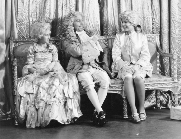 The Royal Princesses Elizabeth (Elizabeth II) as 'Prince Florizel' and Margaret (1930 - 2002) as 'Cinderella' with Hubert Tannar in costume in the Christmas production of 'Cin ...