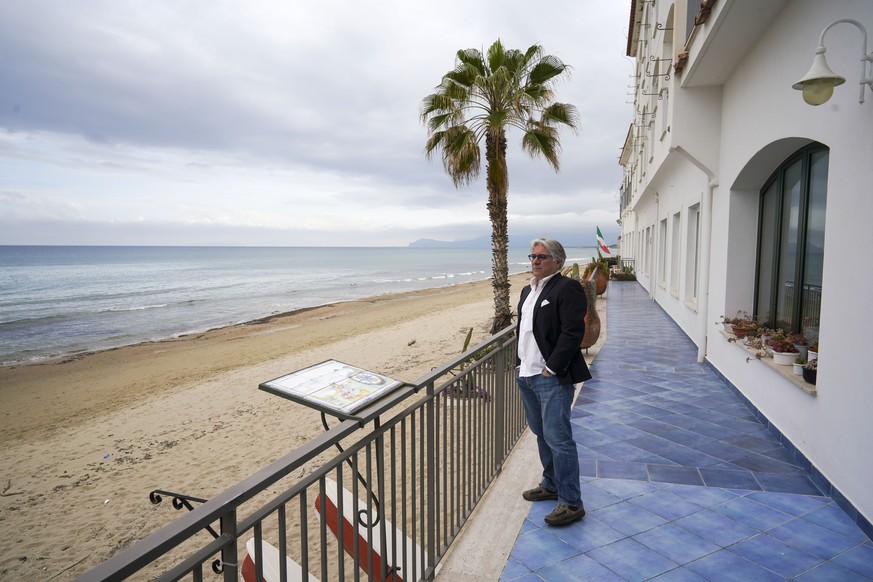 In this picture taken on Tuesday, April 28, 2020, Leone La Rocca, Leone La Rocca, president of Sperlonga tourism association, looks at the empty beach from the terrace of his hotel, in Sperlonga, a fa ...