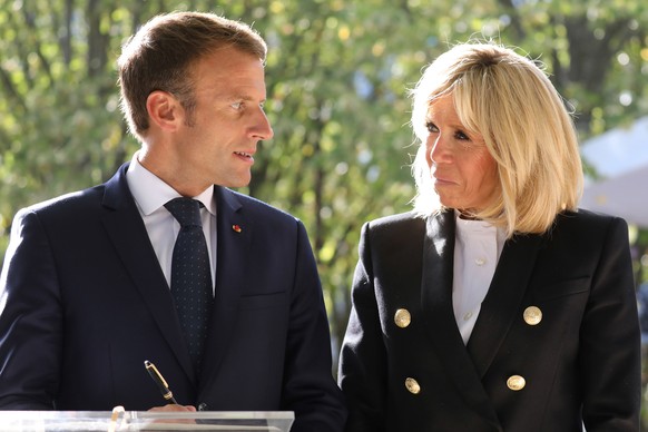 French President Emmanuel Macron, left, and his wife Brigitte Macron attend a national ceremony to pay tribute to the victims of terrorism, at the Invalides in Paris, France, Wednesday, Sept. 19, 2018 ...