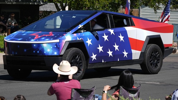 A Tesla Cybertruck wrapped in a patriotic motif takes part in the Colorado 4th at Firestone parade to mark the Independence Day holiday Thursday, July 4, 2024, in Firestone, Colo. Floats, marching ban ...