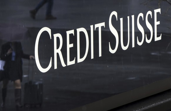 A woman walks past a logo of the Swiss bank Credit Suisse in Zurich, Switzerland, Friday, March 24, 2023. (Michael Buholzer/Keystone via AP)