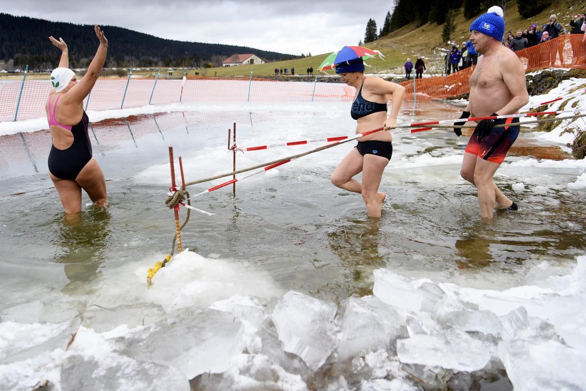 People enter the water to go swimming in the icy waters in the frozen "Lac des Tailleres" lake (1040 meters above sea level), temperature of water is one degree Celsius above zero, during th ...