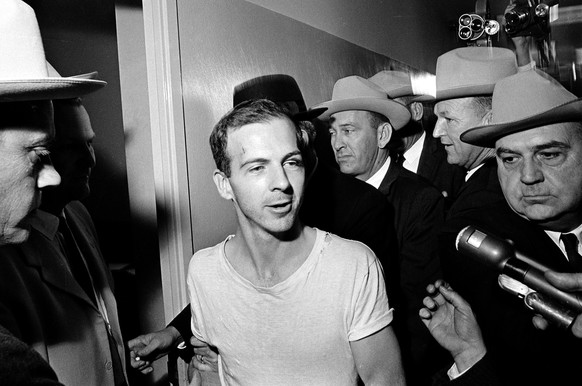 FILE - In this Nov. 23, 1963, file photo, surrounded by detectives, Lee Harvey Oswald talks to the media as he is led down a corridor of the Dallas police station for another round of questioning in c ...