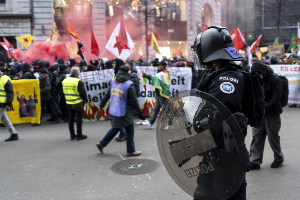 Riot police watches protestors during the Rojava rally against syrian violence and the interventions in Kurdistan and the kurdish controlled areas in Damaskus, in Zuerich, Switzerland on Saturday, 24. ...