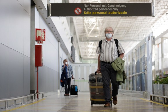 epa08500388 Travelers from Dusseldorf (Germany) wearing masks upon arrival at Tenerife Sur Airport, which has been opened for travelers from most of Europe after lifting the State of Emergency and loc ...