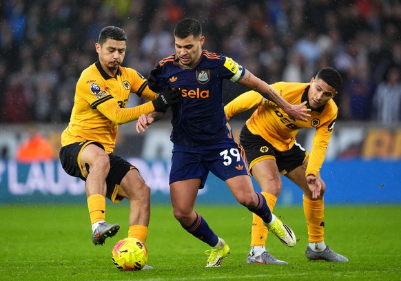 Wolverhampton Wanderers' Andre, left, and Joao Gomes challenge Newcastle United's Bruno Guimaraes during the English Premier League soccer match between Wolves and Newcastle United in Wolver ...