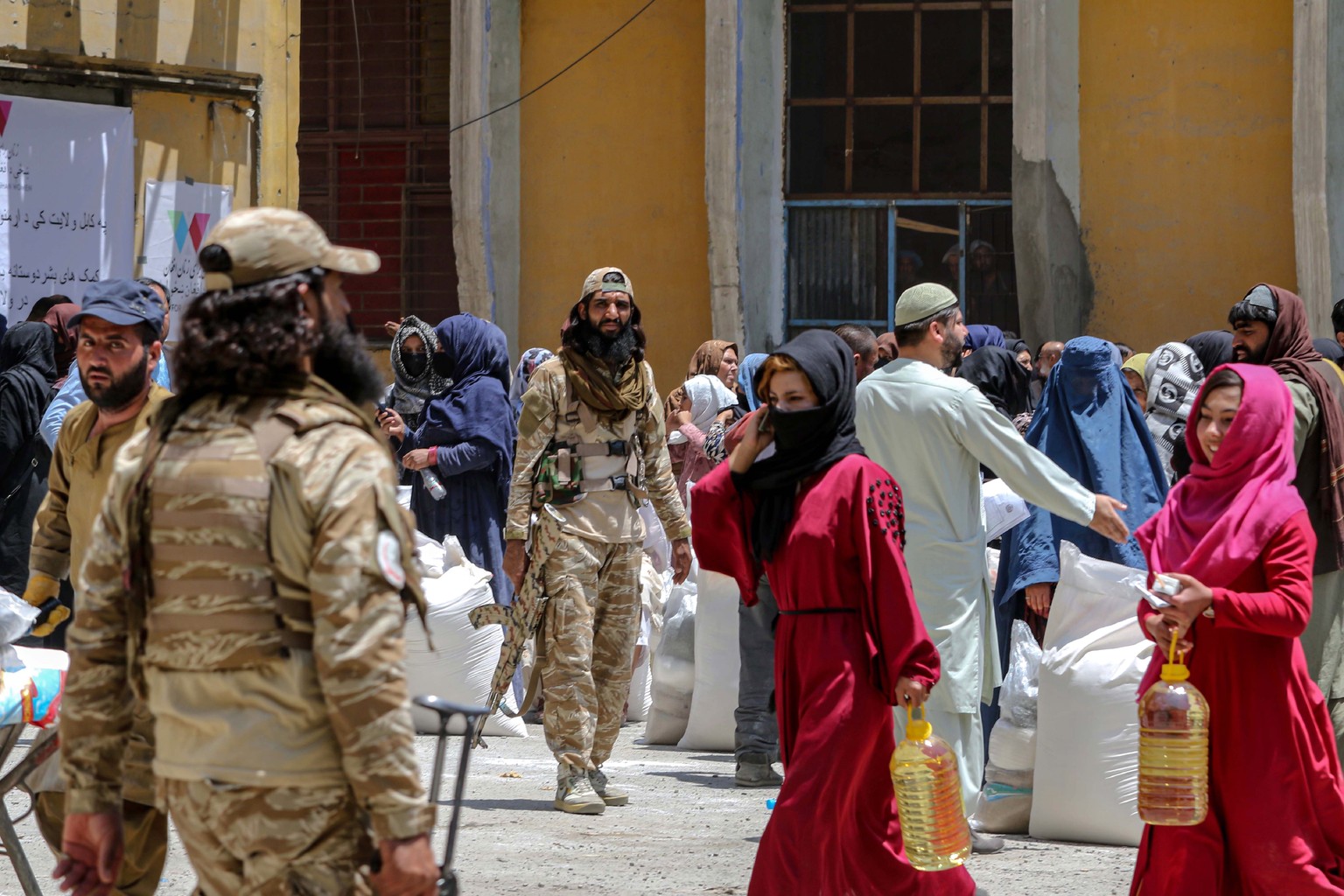 epa10783108 Afghans receive food rations in Kabul, Afghanistan, 03 August 2023. In partnership with the Ministry of Immigrants and Returnees Affairs, the &#039;Women for Afghan Women&#039; organizatio ...