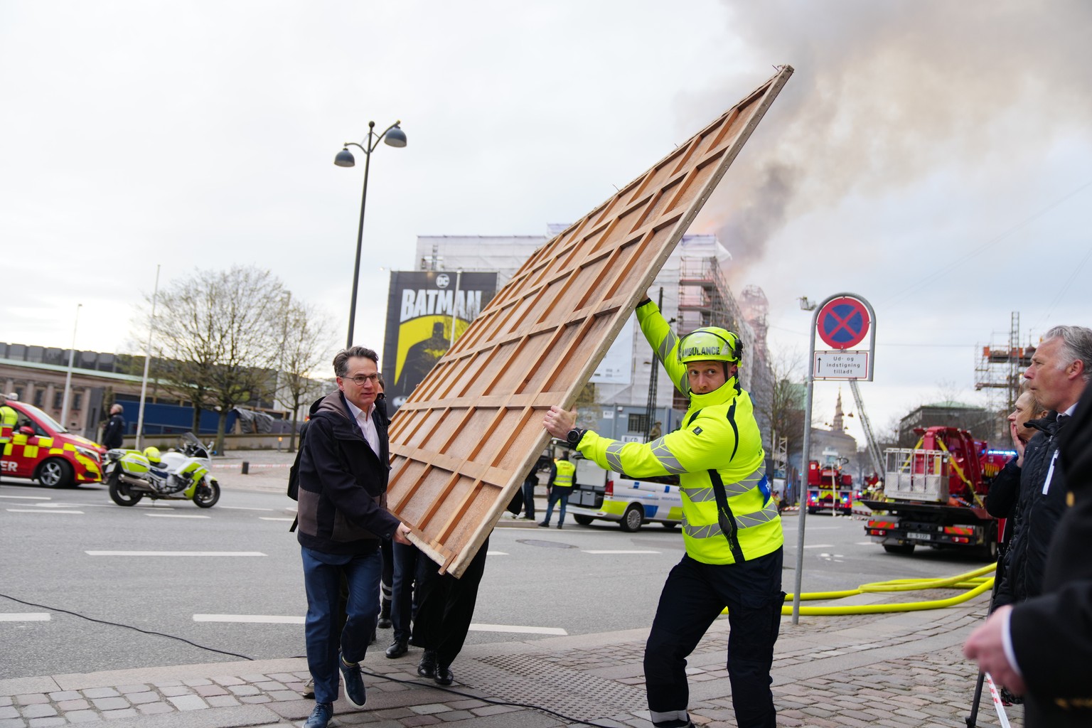epa11281327 Locals carry paintings and other objects as a fire burns the old Stock Exchange (Boersen) in Copenhagen, Denmark, 16 April 2024. A violent fire broke out in the building which is under ren ...